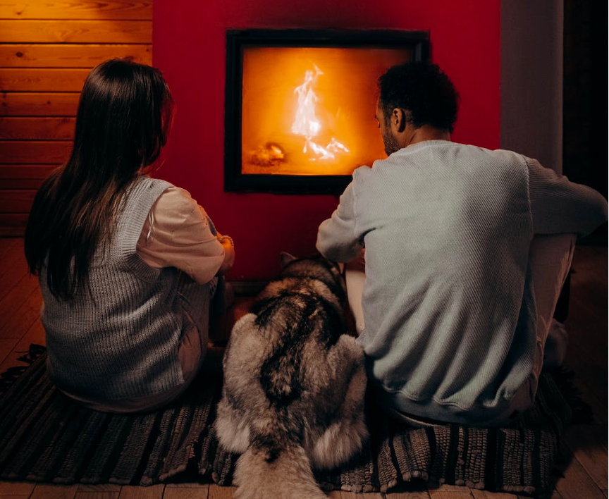 Couple sitting by fireplace.